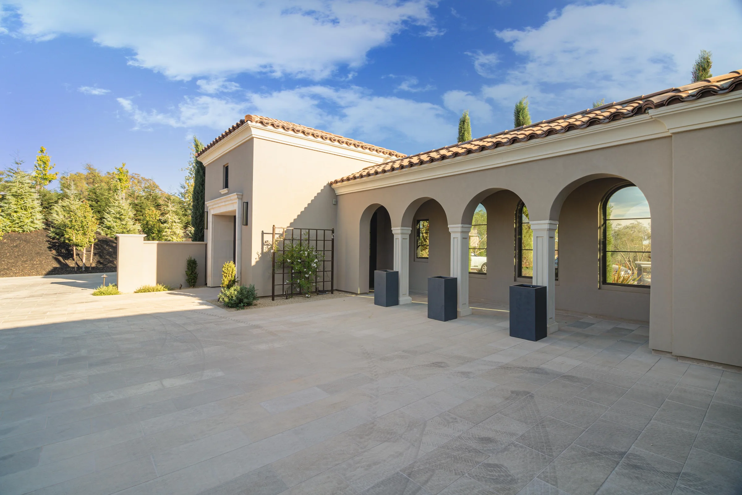 A courtyard arcade with repeated arches, fluted cast-stone columns, and a continuous cornice