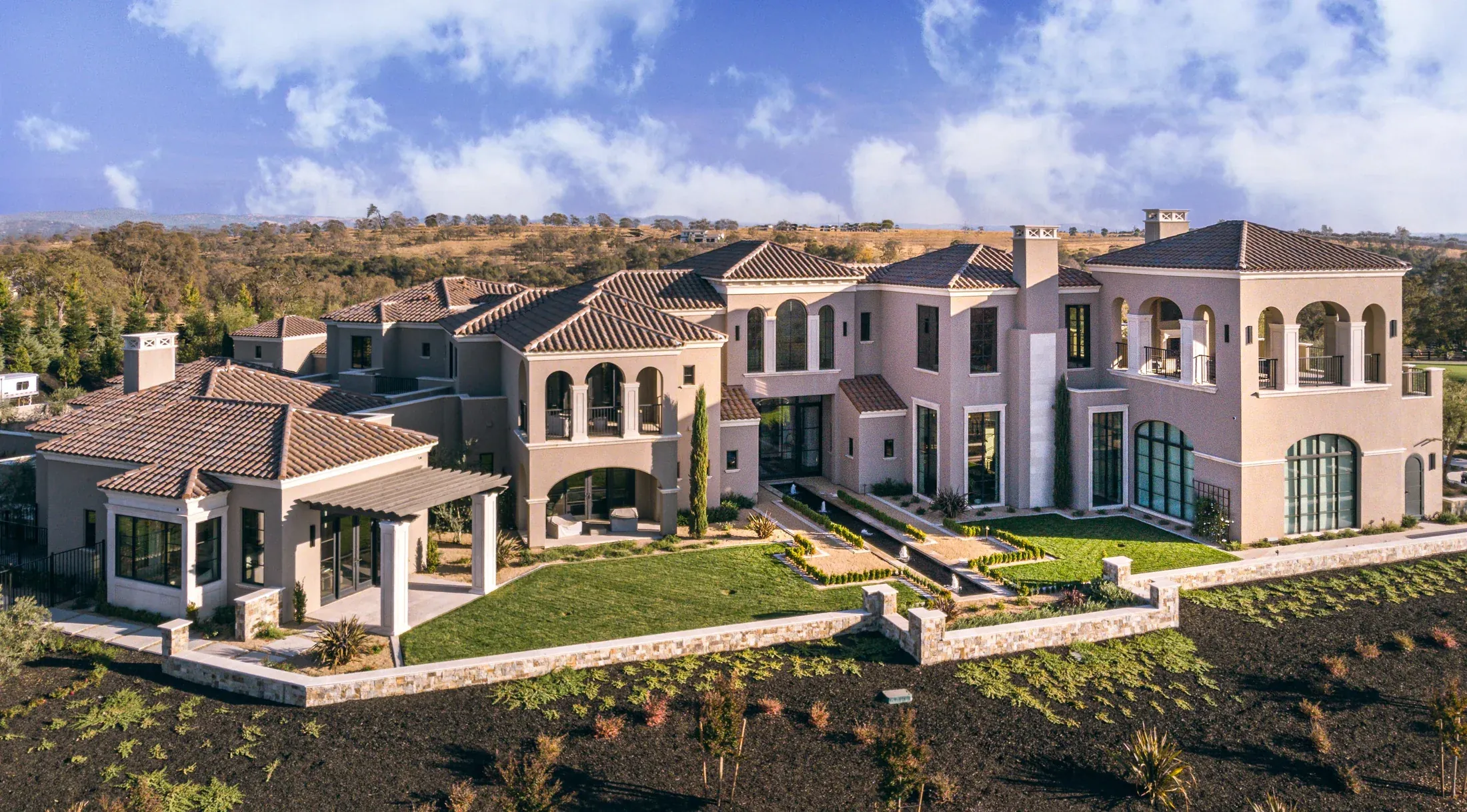 Estate landscape connected by paving, walls, caps, and architectural stone